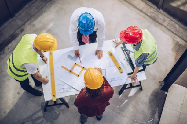 Construction workers and architects working on construction site